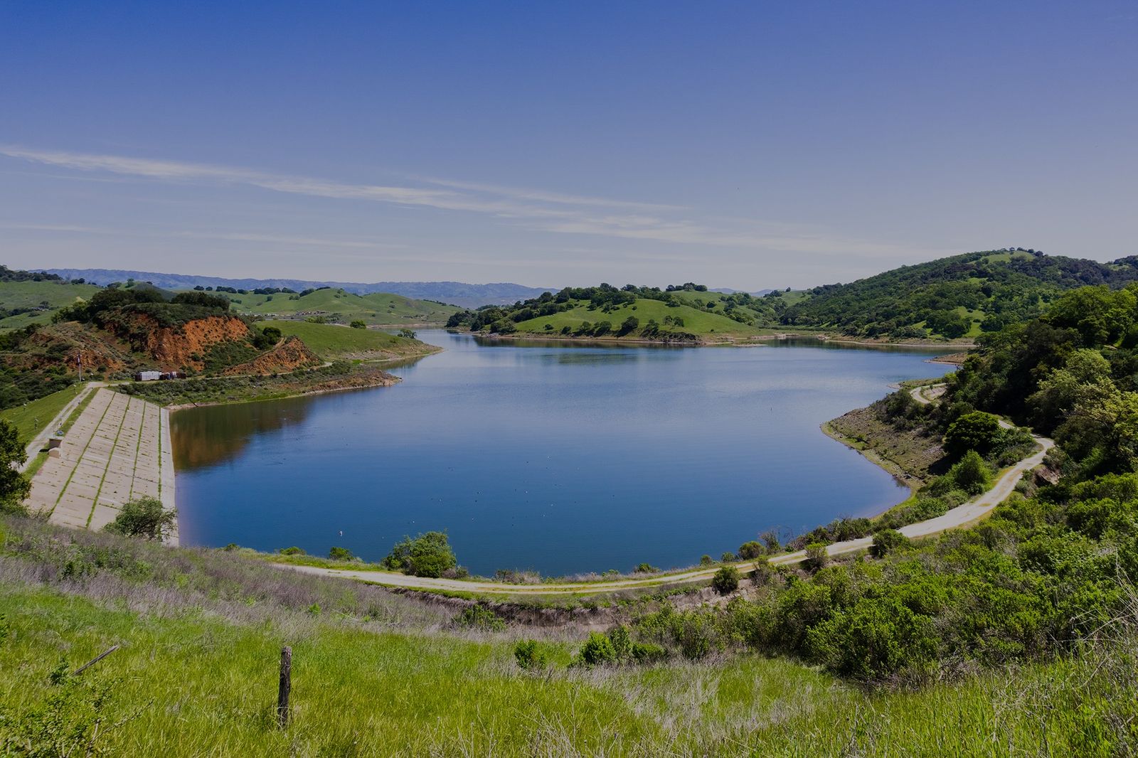 A reservoir surrounded by green watershed hills